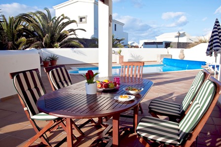 View across pool from terrace with table/chairs