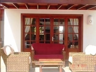 Rattan chairs beneath shaded pergola